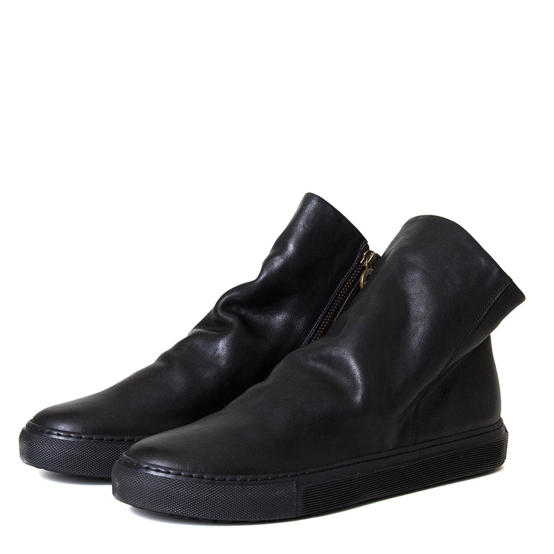 Pair of black leather ankle boots with a gold zipper on a white background